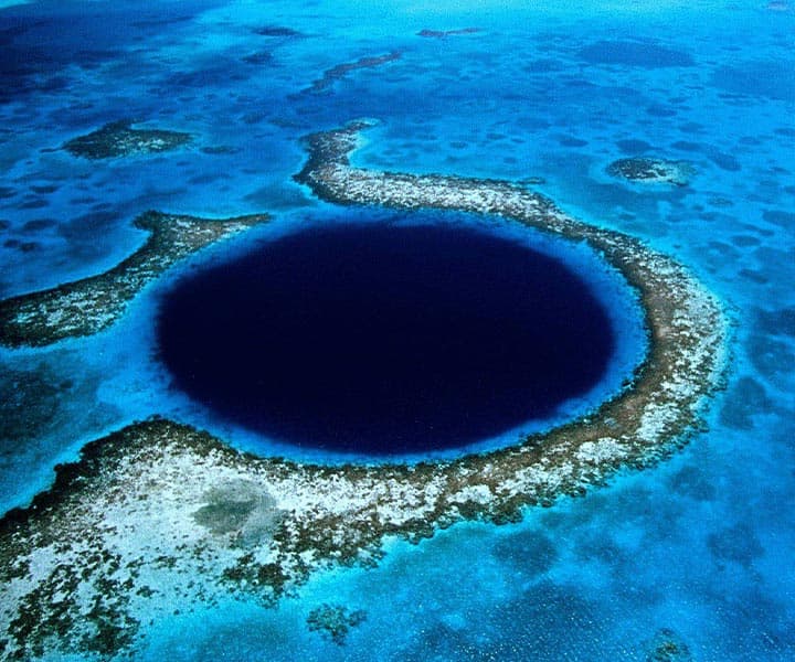Aerial view of the Great Blue Hole surrounded by turquoise waters and coral reefs.
