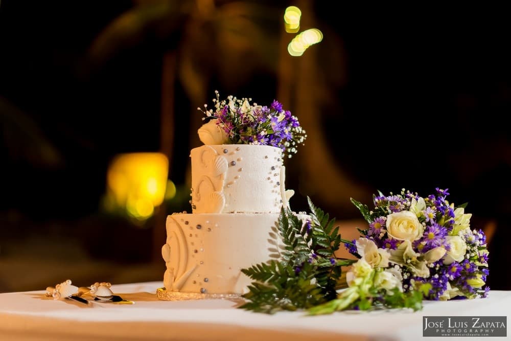 A beautifully decorated three-tier wedding cake adorned with fresh flowers.