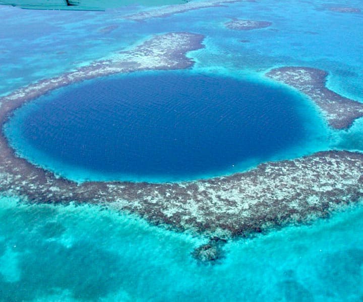 Aerial view of the Great Blue Hole surrounded by turquoise waters and coral reefs.